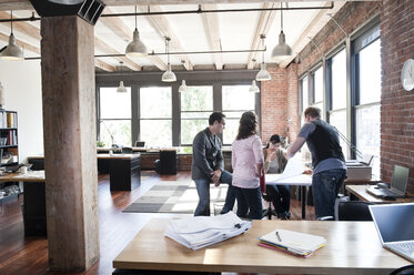 Mixed race group of people meeting to brainstorm an issue in a creative office. - MINF08565