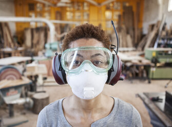 Nahaufnahme einer schwarzen Fabrikarbeiterin mit Schutzbrille und Staubnasenmaske in einer Holzverarbeitungsfabrik. - MINF08571