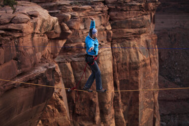 Ein weiblicher Highliner läuft über eine Highline in der Fruit Bowl in Moab, Utah, USA. - AURF00148