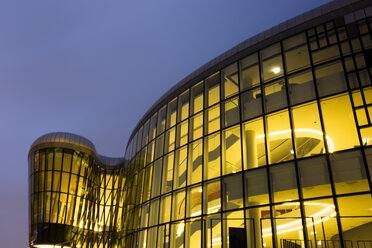 Poland, Krakow, glass facade of lighted Congress Center at blue hour - FCF01459