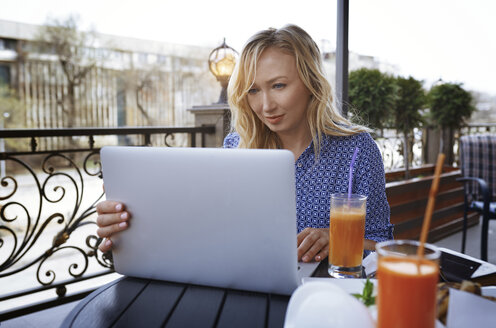 Weibliche Bloggerin arbeitet in einem Café, mit Laptop - AZF00077