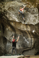 Eine Frau beim Bouldern mit einem Spotter im Yosemite Valley, Kalifornien, USA. - AURF00159