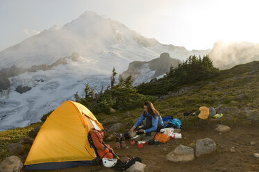 Eine Frau kocht eine Mahlzeit beim Zelten unterhalb des Mount Baker, Mount Baker Wilderness, Bellingham, Washington. - AURF00166