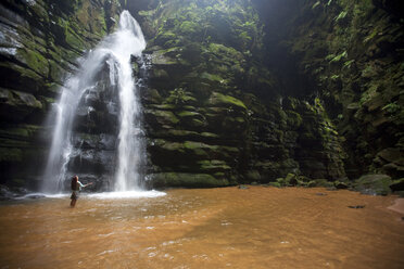 Eine Frau beobachtet einen Wasserfall in Brasilien. - AURF00172