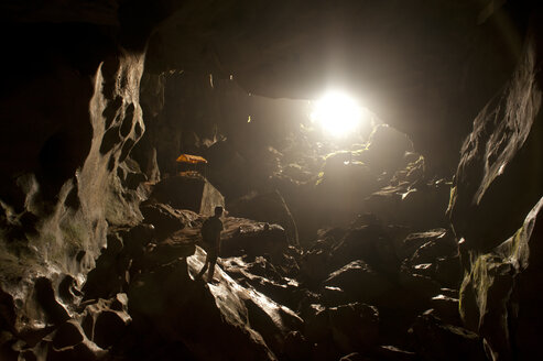 Ein Reisender blickt auf das Licht am Eingang einer Höhle in Vang Vieng, Laos, Asien. - AURF00182