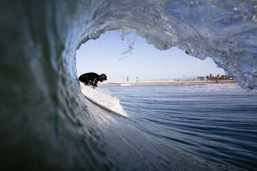 Ein Surfer mit Kapuze macht sich in Port Hueneme, Kalifornien, für einen Lauf bereit. - AURF00183
