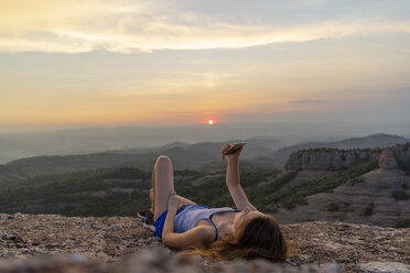 Spain, Catalonia, Sant Llorenc del Munt i l'Obac, woman taking pictures in the mountains with her smartphone - AFVF01385