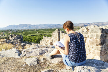 Griechenland, Peloponnes, Argolis, Tiryns, archäologische Stätte, Touristin liest Reiseführer - MAMF00197