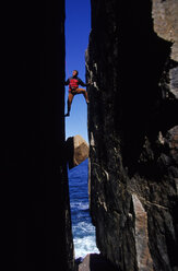 Ein Mann klettert zwischen zwei Felsen, Maine, USA. - AURF00188