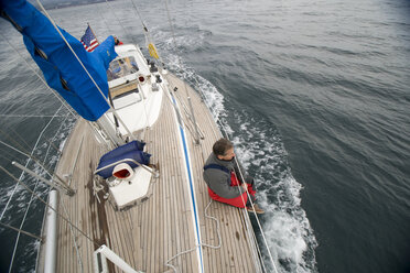 Ein Mann hängt auf dem Deck seines Segelbootes herum. - AURF00193