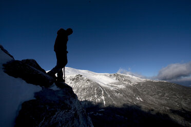 Ein Mann wandert auf der Boott Spur Link, als sich der Sturm legt und den Blick auf die Tuckerman's Ravine und den Gipfel des Mt. Washington freigibt. - AURF00199