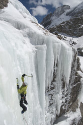 Ein Mann klettert im Eis einen gefrorenen Wasserfall am Willow Lake in den Sangre De Cristo Mountains, Crestone, Colorado, hinauf. - AURF00210