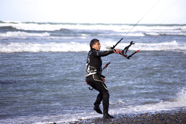 Ein männlicher Kitesurfer bereitet sich auf seine nächste Fahrt vor. - AURF00227