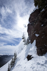 Ein männlicher Skifahrer springt an einem sonnigen Tag in Colorado von einer Klippe. - AURF00255