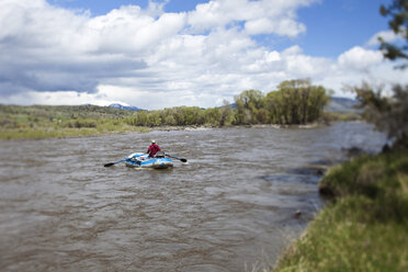 Ein Mann flößt an einem schönen Tag in Montana einen Fluss hinunter. - AURF00256