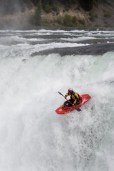 Young man kayaking over Kootenai Falls on Kootenai River near Libby, Montana. - AURF00280