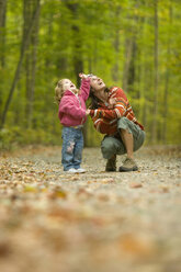 Junge Frau und Kind auf Erkundungstour im Wald am ländlichen Lake Ossipee, New Hampshire. - AURF00297
