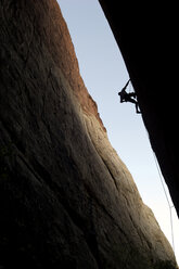 Ein Bergsteiger klettert in Nevada eine rote Felswand hinauf und wird dabei von einer Silhouette umgeben. - AURF00337