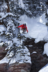 Ein Snowboarder springt von einer Klippe in den Pulverschnee in Colorado. - AURF00349