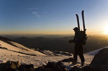 Ein Skitourengeher genießt die Aussicht beim Aufstieg auf den Mount Shasta bei Sonnenaufgang, CA. - AURF00384