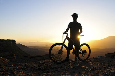 A silhouette of a mountain biker at sunset on Gooseberry Mesa in southern Utah. - AURF00393