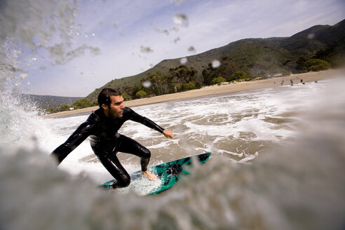 Ein Surfer macht beim Surfen in Malibu, Kalifornien, einen Bottom Turn. - AURF00396