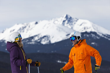 Ein Skifahrerpaar lacht und unterhält sich an einem sonnigen Tag in Vail, Colorado. - AURF00398