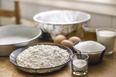 Ingredients for a cake, wheat flower, sugar, milk and eggs on pastry board - ACPF00230