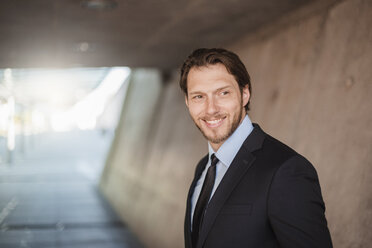 Portrait of smiling businessman in underpass - DIGF04840