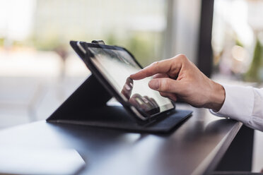 Close-up of businessman using tablet in a cafe - DIGF04864