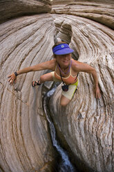Woman scrambling up desert canyon, Grand Canyon, Arizona. - AURF00454