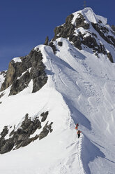 Zwei Männer wandern mit Skiern den Weg hinauf, um abseits der Pisten in St. Anton am Arlberg, Österreich, unverspurten Schnee zu fahren. - AURF00485