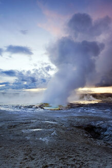 Der Clepsydra-Geysir bricht bei Sonnenuntergang im Lower Geyser Basin des Yellowstone-Nationalparks in Wyoming aus. - AURF00497