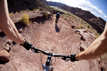 Mountainbiker fahren auf einer Strecke mit Blick auf den Colorado River in der Nähe von Moab, Utah. - AURF00529