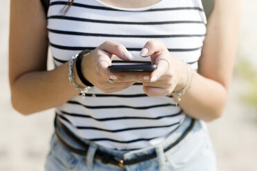 Nahaufnahme einer Frau, die ein Mobiltelefon benutzt - GIOF04140