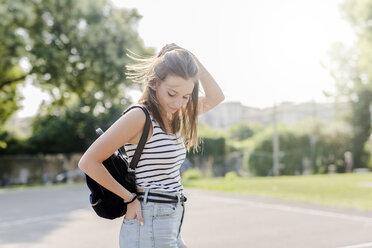 Portrait of smiling young woman with backpack outdoors in summer - GIOF04144