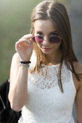 Porträt einer jungen Frau mit Sonnenbrille im Freien - GIOF04174