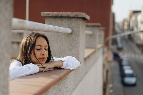 Portrait of young woman relaxing on roof terrace stock photo