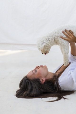 Junge Frau hat Spaß mit Hund auf Dachterrasse, lizenzfreies Stockfoto