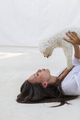 Young woman having fun with dog on roof terrace - AFVF01416