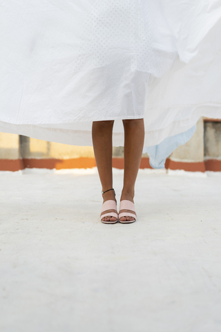 Beine einer jungen Frau, die sich hinter einem trockenen Bettlaken versteckt, lizenzfreies Stockfoto
