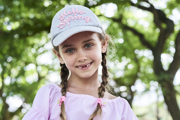 Portrait of little girl with green eyes braids and cap, smiling - IGGF00510