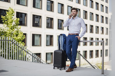 Businessman standing in the city talking on cell phone - DIGF04885