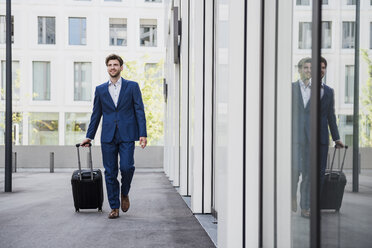 Smiling businessman with baggage in the city on the move - DIGF04906