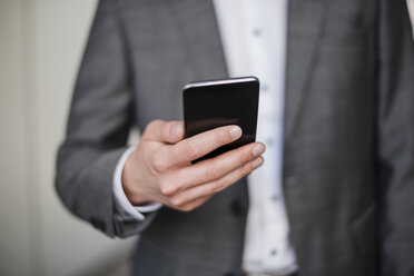 Close-up of businessman holding cell phone - DIGF04937