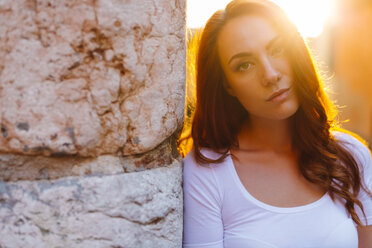 Portrait of redheaded woman leaning against wall at sunset - GIOF04221