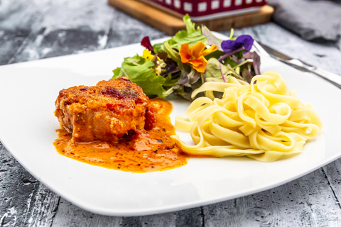 Toskanisches Schweinefilet mit Tagliatelle und Salat, lizenzfreies Stockfoto