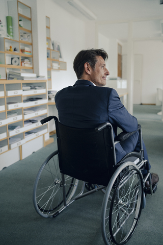 Behinderter Geschäftsmann sitzt im Rollstuhl, lizenzfreies Stockfoto