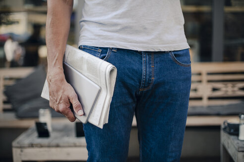 Älterer Mann mit Zeitung und digitalem Tablet in der Hand, Mittelteil - GUSF00982