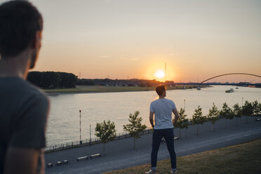 Zwei Freunde beobachten den Sonnenuntergang am Fluss - GUSF01001